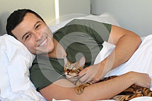 Cute ethnic man sleeping with his cat