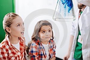 Cute exited girls looking at the chemical reaction