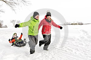 Cute Family Pulling Sledge Through Snowy Landscape