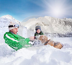 Cute family scene: father and son play with dog during mountain