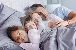 Cute family sleeping in bed