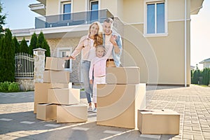 Cute family unpacking cardboard boxes while moving to a new house