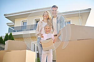 Cute family unpacking cardboard boxes while moving to a new house