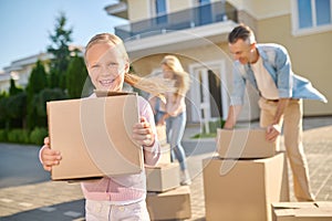 Cute family unpacking cardboard boxes while moving to a new house