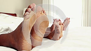 Cute family wiggling toes in bed
