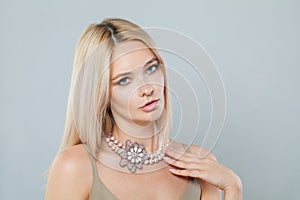 Cute fashion jewelry model woman. Lady with fresh clean skin, blonde hair and necklace on her neck
