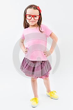 Cute fashion-monger girl in pink dress tshirt and skirt red glasses frames.