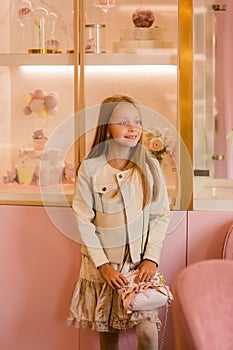 Cute fashionable girl beautifully dressed with a small handbag. shopping concept of modernity