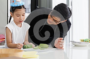 Cute father and daughter helped prepare vegetables To cook Vegetable salad