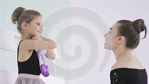 Cute Female ballet teacher gives his sad student a toy