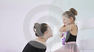 Cute Female ballet teacher gives his sad student a toy