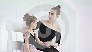 Cute Female ballet teacher reassures his sad student