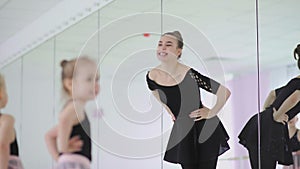 Cute Female ballet teacher is teaching a lesson to little girls