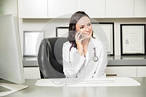 Cute female doctor talking over the phone