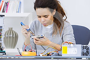 cute female engineer at home working on electronics