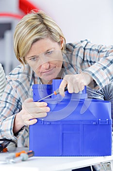 Cute female engineer at home working on technology