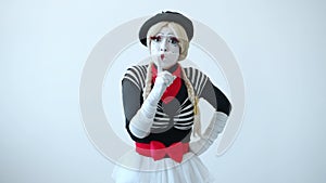 Cute female mime shushing touching lips with finger asking to keep secret