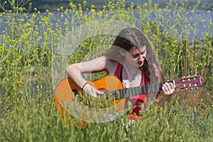 Cute female Musician sitting on green Grass photo