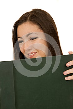 Cute female student reading a large text book smiling