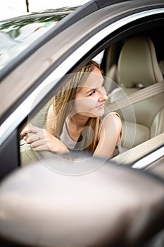 Cute female teen driver enjoying her freshly acquired driving license