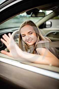 Cute female teen driver enjoying her freshly acquired driving license