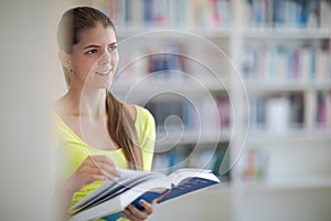 Cute female universit student with books in library