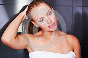 Cute female wrapped in the towel after a bath. Pretty elegant woman wrapped in a bath towel after a shower.