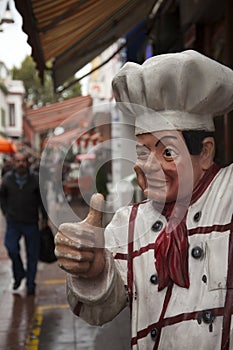 Cute fibreglass statue of cook at street making thumbs up and winking