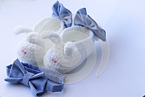 Cute first white baby booties with bows and little blue bow tie