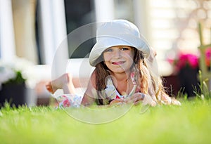 Cute four-year girl lying on the grass