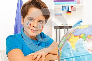 Cute French boy learning geography with the globe