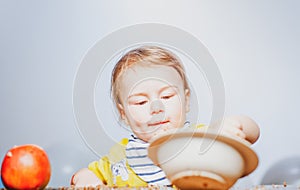 Cute funny babies eating, baby food. Funny kid boy with plate and spoon.