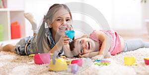 Cute funny children playing with dishware toys at home