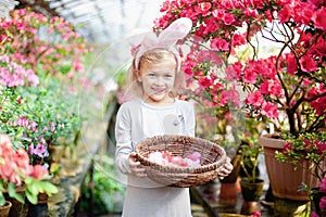 Cute funny girl with Easter bunny ears at garden. easter concept. Laughing child at Easter egg hunt