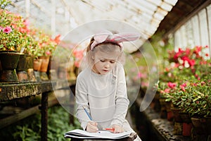 Cute funny girl with Easter bunny ears at garden. easter concept. Laughing child at Easter egg hunt