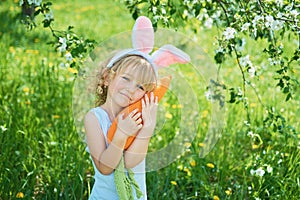 Cute funny girl with Easter eggs and bunny ears at garden. easter concept. Laughing child at Easter egg hunt