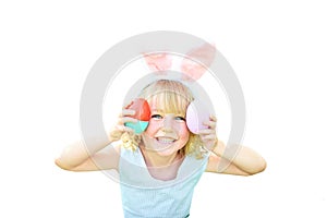 Cute funny girl with Easter eggs and bunny ears at garden. easter concept. Laughing child at Easter egg hunt