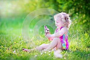 Cute funny girl eating ice cream in sunny garden