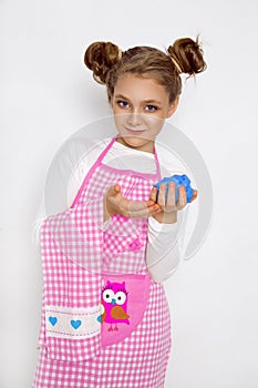Cute funny girl with slime in the kitchen. The girl cooks and bakes her muffins, makes a cake and slime.