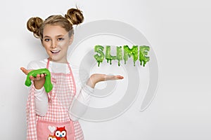 Cute funny girl with slime in the kitchen. The girl cooks and bakes her muffins, makes a cake and slime.