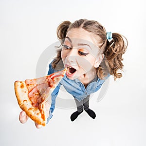 Cute funny girl with two pony tails eating pizza - wide angle shot