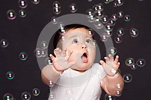 Cute funny happy amazed baby with bubbles