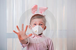 Cute funny kid on Easter egg hunt. Child boy in bunny ears wearing medicine mask. Happy Easter on quarantine coronavirus