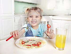 Cute funny kid eating noodles.Little girl have a meal.Happy preschooler lifestyle portrait