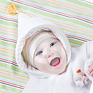 Cute funny laughing baby girl on colorful blanket