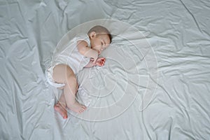 Cute funny newborn little boy peacefully sleeping on white sheets in bed or crib. Baby goods packaging template. Healthy