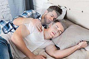 Cute gay couple sleeping together in bed