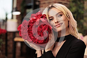 Cute gifriend posing with valentines day red roses bouquet