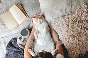 Hygge concept with cat, book and coffee in the bed photo