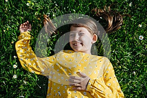 cute girl 8 years old lying on the grass